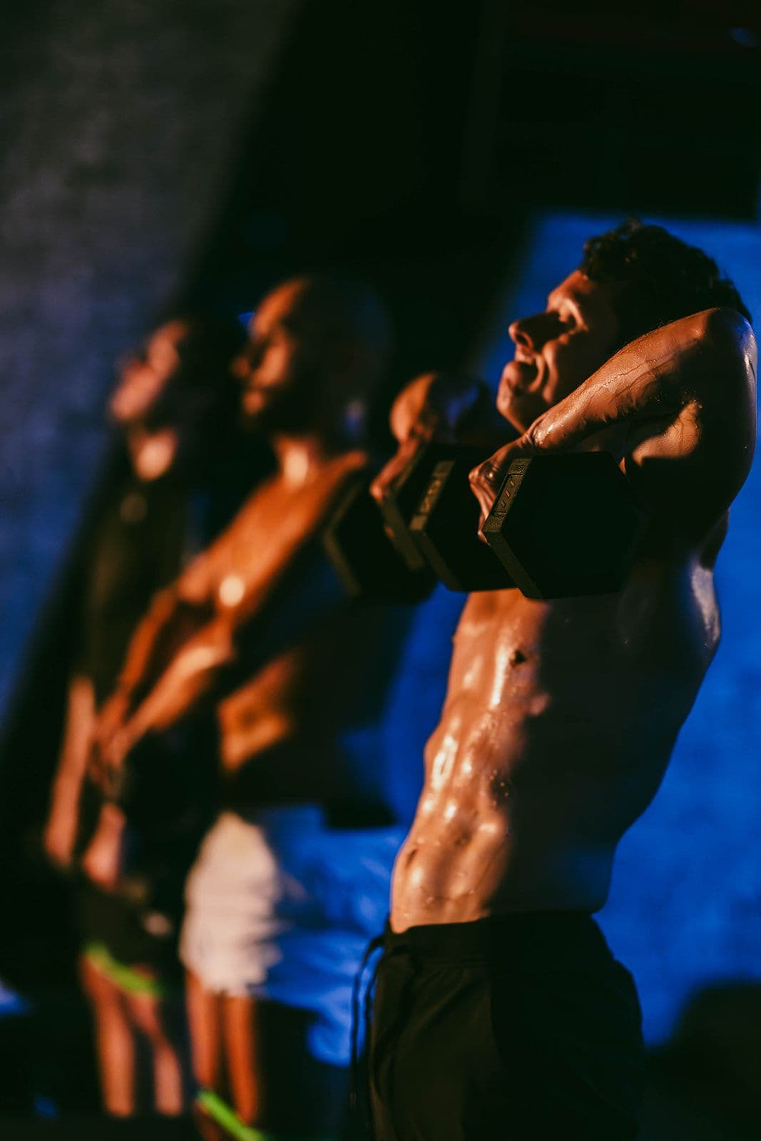 Focused shot of athletes performing intense weight training, showcasing strength, discipline, and peak performance in a high-energy fitness environment.